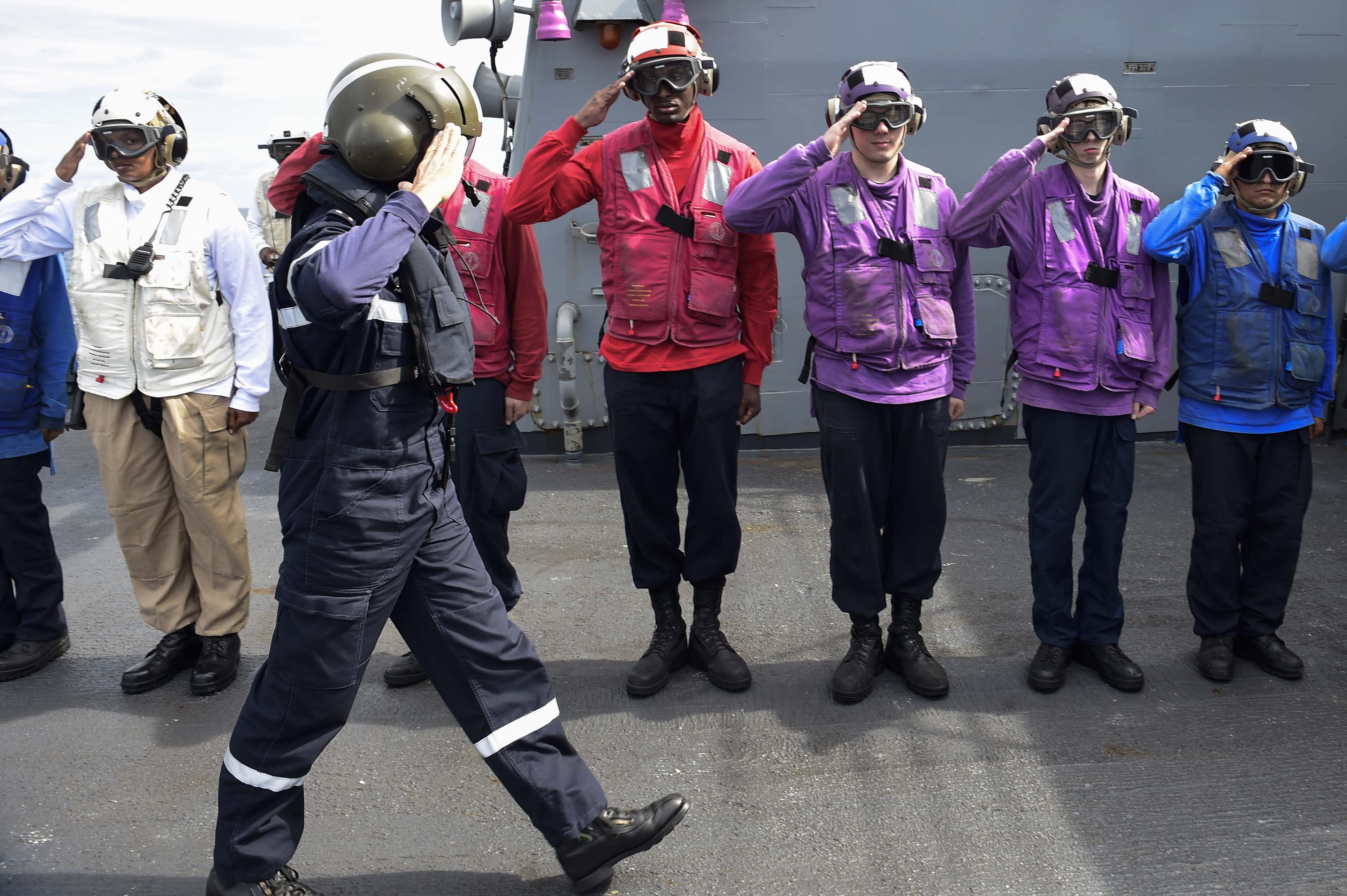 Des marins rendent les honneurs à l'arrivée du contre-amiral Lebas à bord de l'USS Ross
