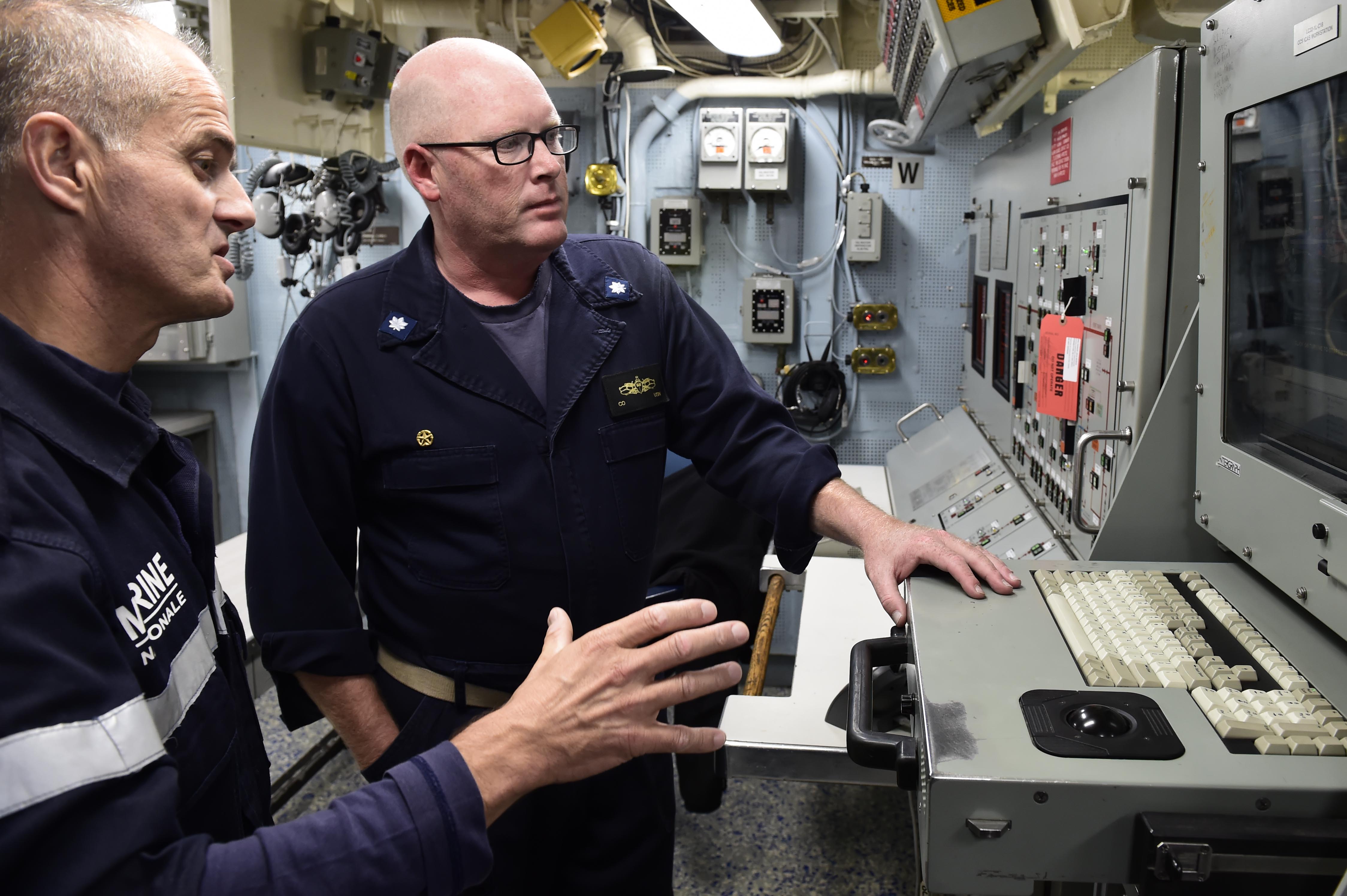 Le Cmdr. Russell Caldwell, commandant de l'USS Ross, fait visiter son destroyer au contre-amiral Lebas