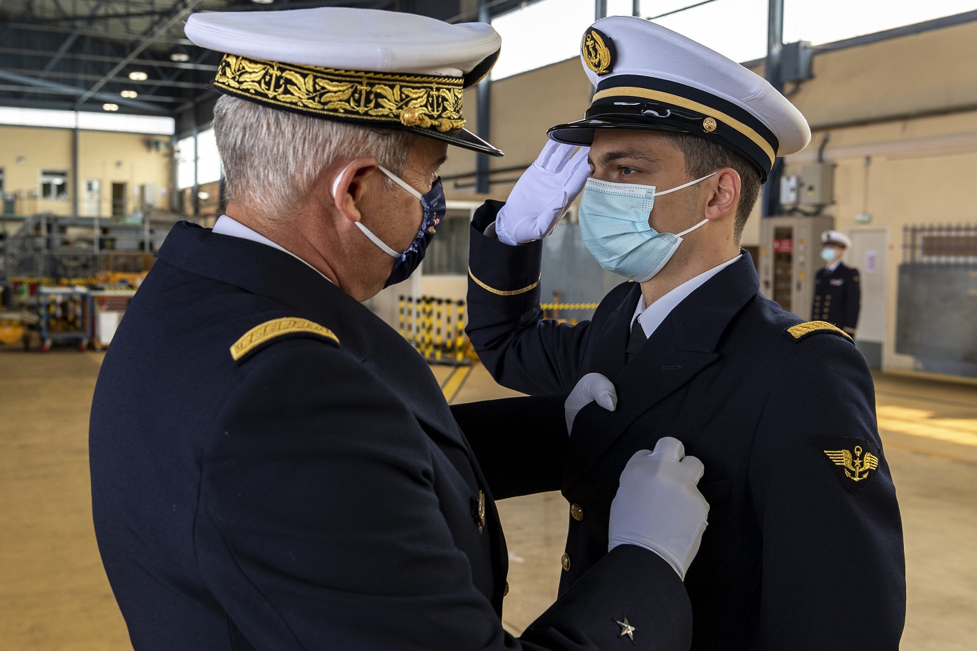 Le contre-amiral Éric Janicot remet son insigne à un nouveau pilote d'hélicoptères