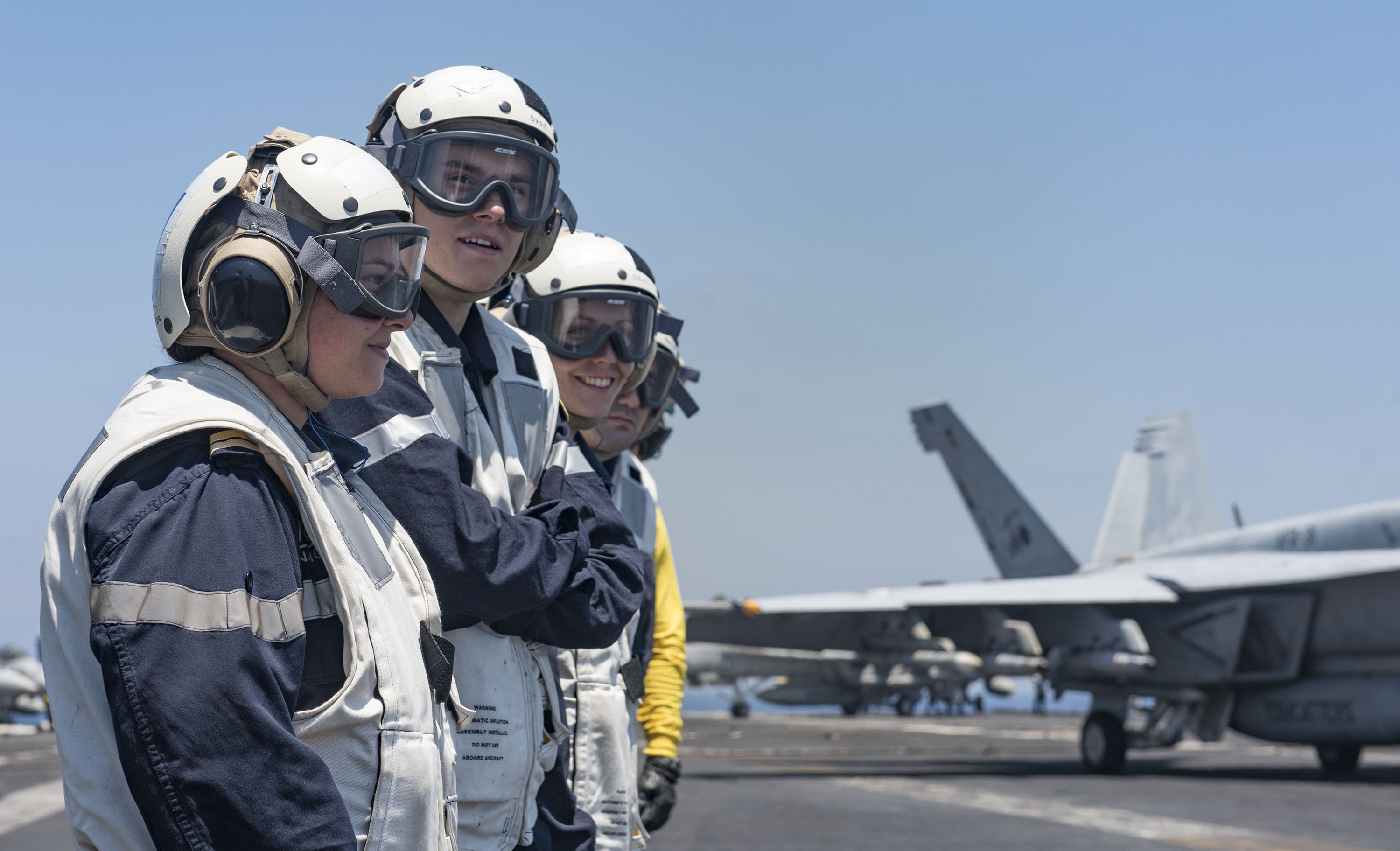 Des marins de la frégate Chevalier Paul assistent aux opérations aériennes sur le pont de l'USS George H.W. Bush