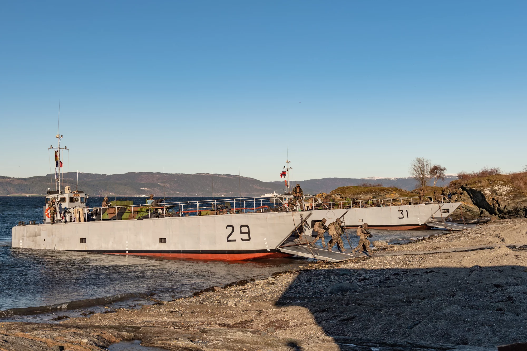 Des soldats débarquent d'un chaland de transport de matériel
