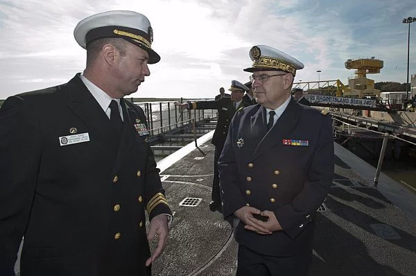 Le Cmdr. Doug Adams, commandant de l'USS Rhode Island, accueille l'amiral Rogel à son bord