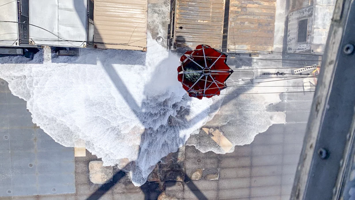 Un hélicoptère largue de l'eau sur la coque de l'USS Bonhomme Richard pour la refroidir