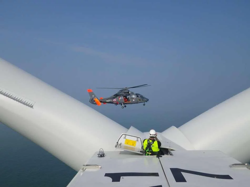 Un hélicoptère Dauphin de la Marine nationale s’entraîne dans un parc éolien off-shore