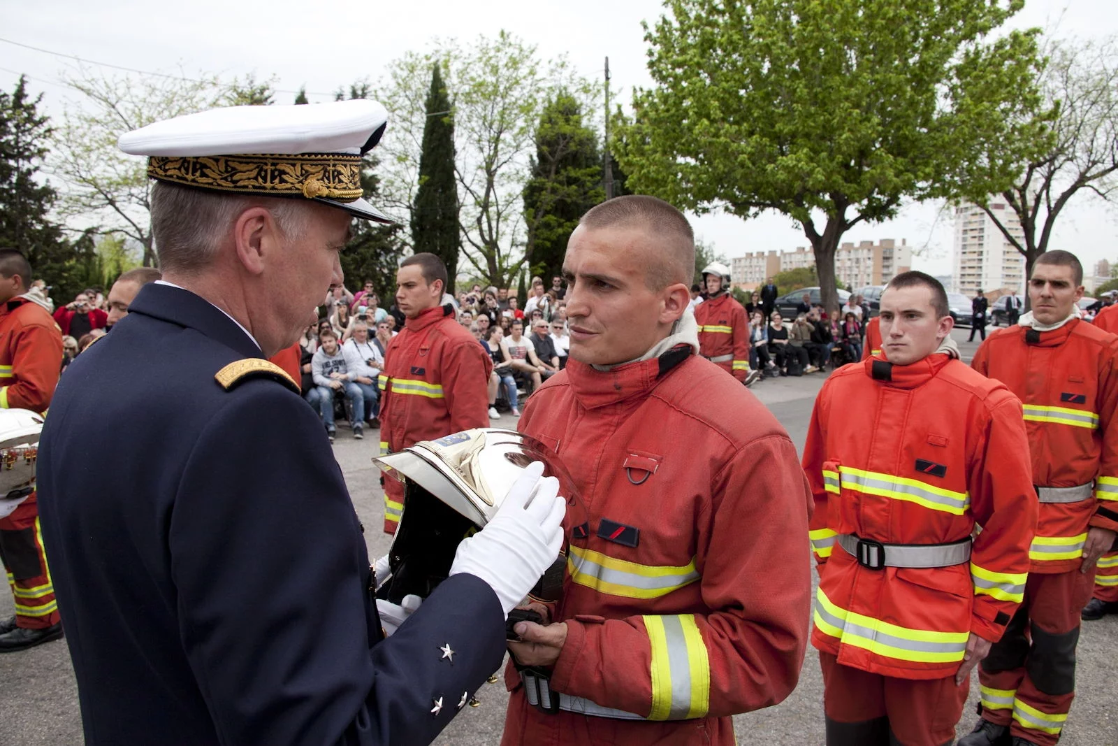 Un nouveau marin-pompier reçoit son casque des mains du vice-amiral L’Hénaf