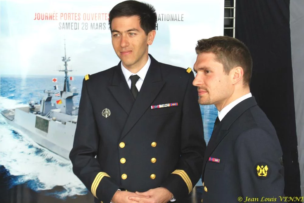 Les 2 marins devant les affiches de la campagne