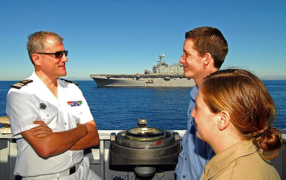 Le commandant du Prairial discute avec 2 marins américains du Tarawa