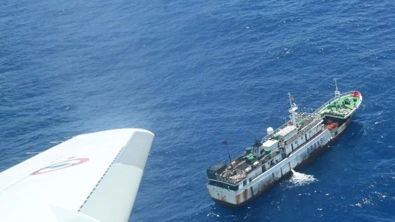 Un avion de surveillance maritime Falcon-200 Gardian survole un bâteau de pêche
