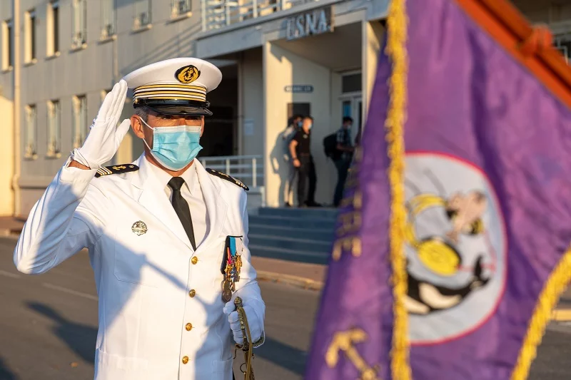 Le nouveau directeur salue le fanion du CIRA