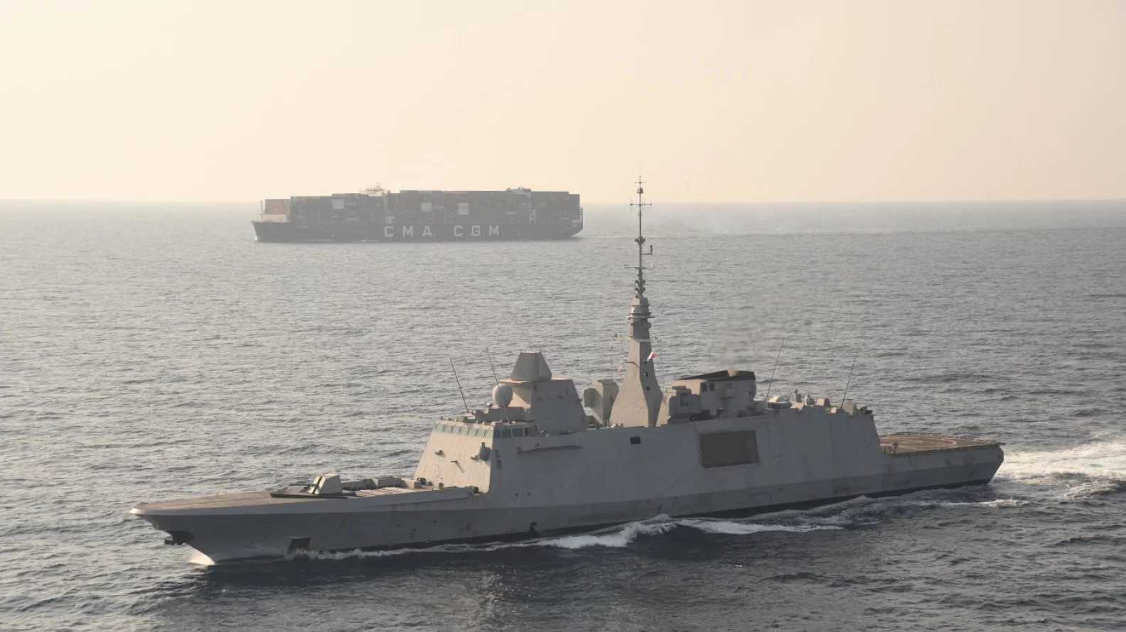 Une frégate escorte un porte-conteneurs en mer Rouge
