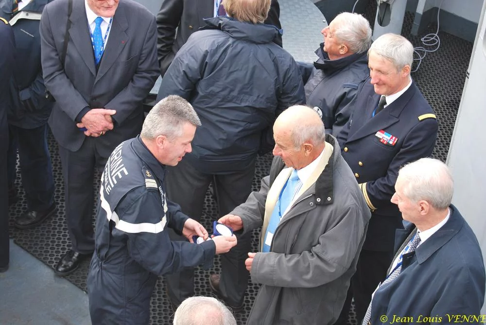 Le commandant actuel remet à un de ses prédécesseurs une médaille et une casquette