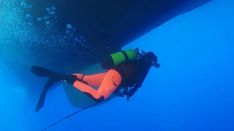 Des plongeurs de bord effectuent une visite de la coque du patrouilleur Cdt Blaison