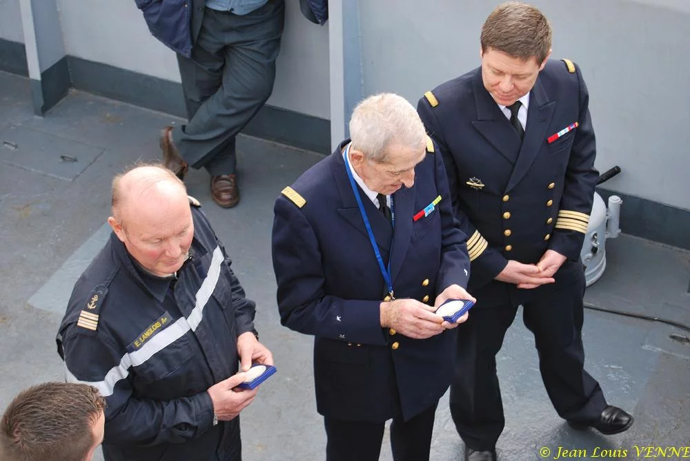 Le commandant actuel remet à un de ses prédécesseurs une médaille et une casquette