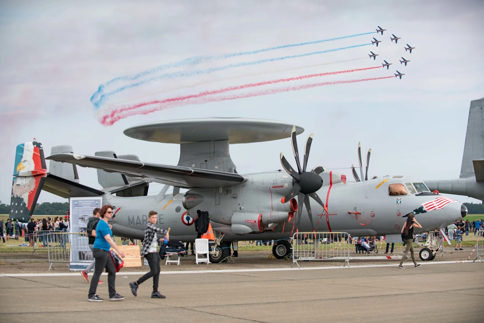 Un avion de guet aérien E2C - Hawkeye survolé par la patrouille de France