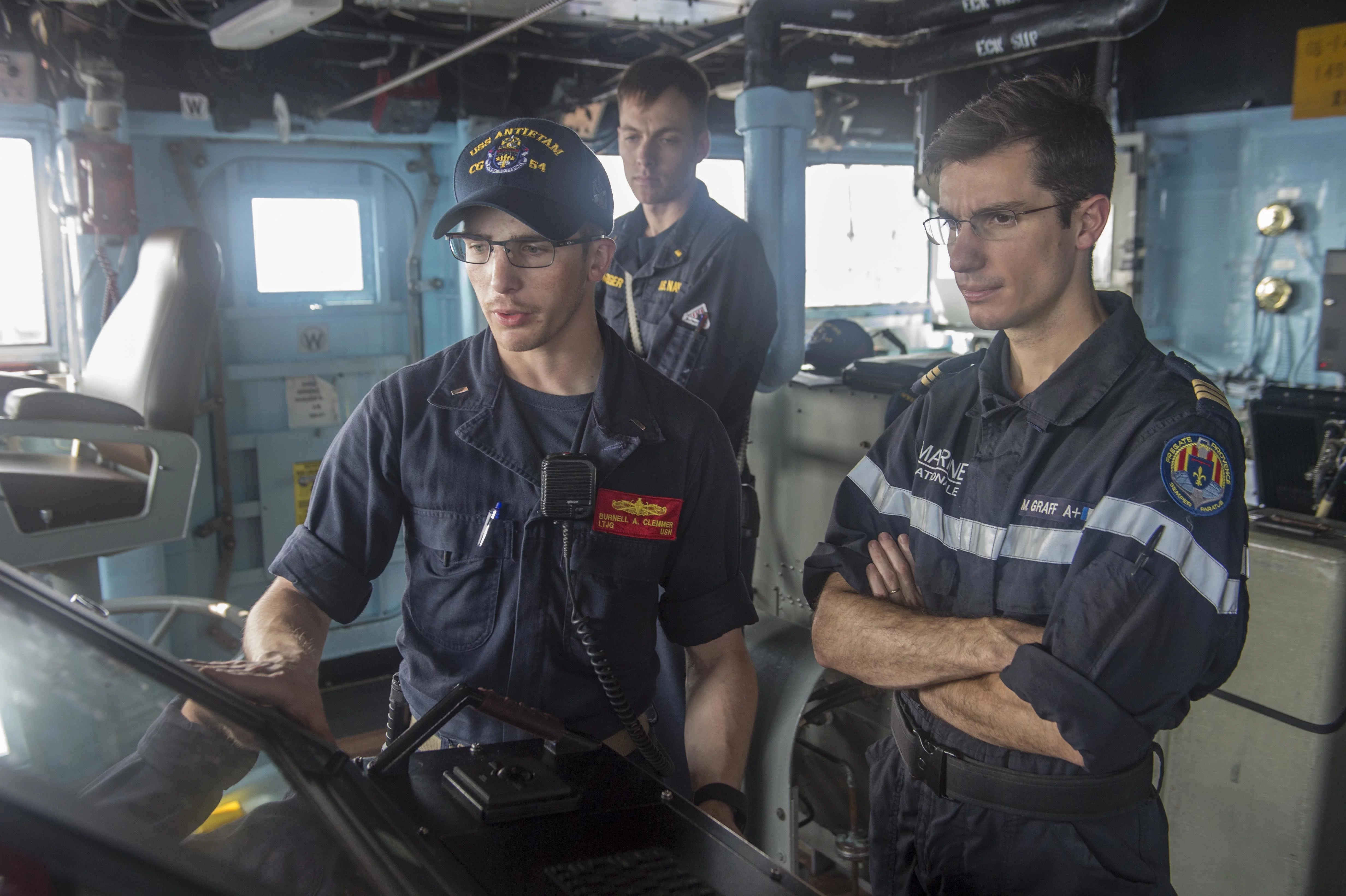 Un officier américain fait visiter le croiseur USS Antietam à un de ses homologues de la frégate Provence