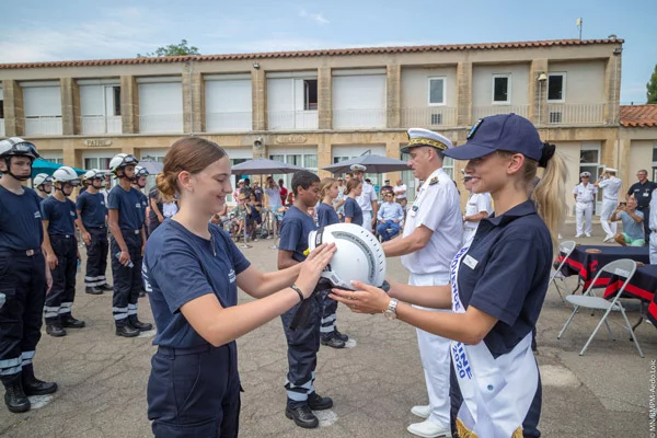 Mlle Lou Ruat, Miss Provence, remet son casque à une jeune marin-pompier