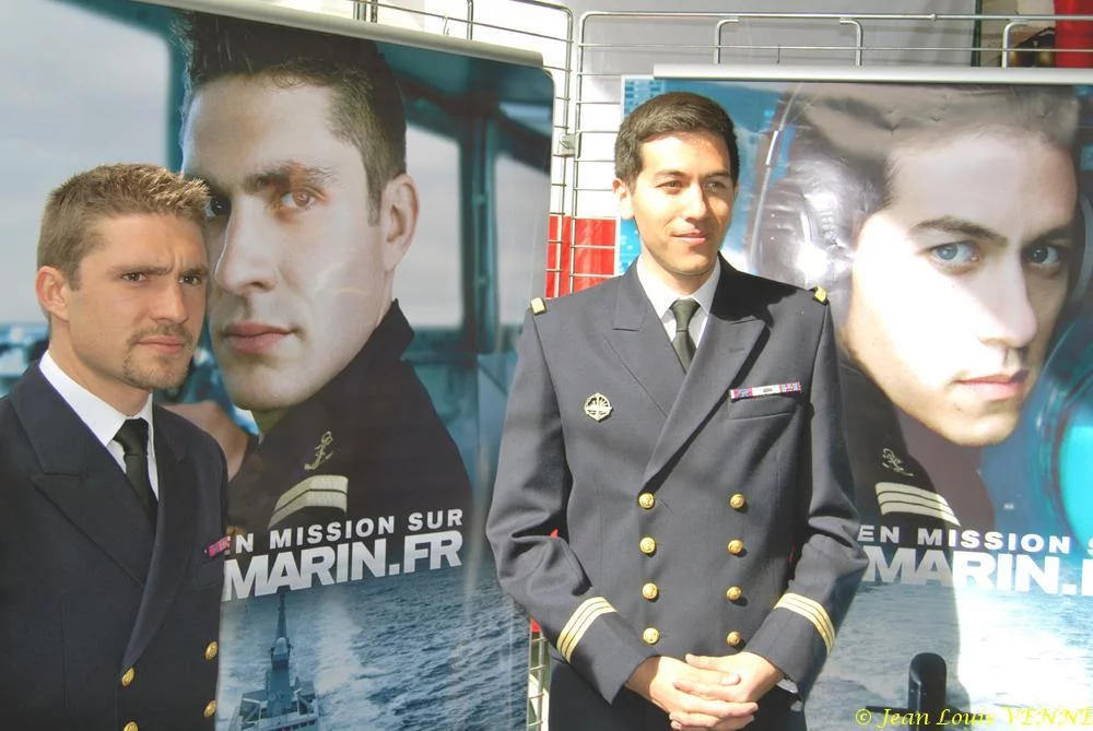 Les 2 marins devant les affiches de la campagne
