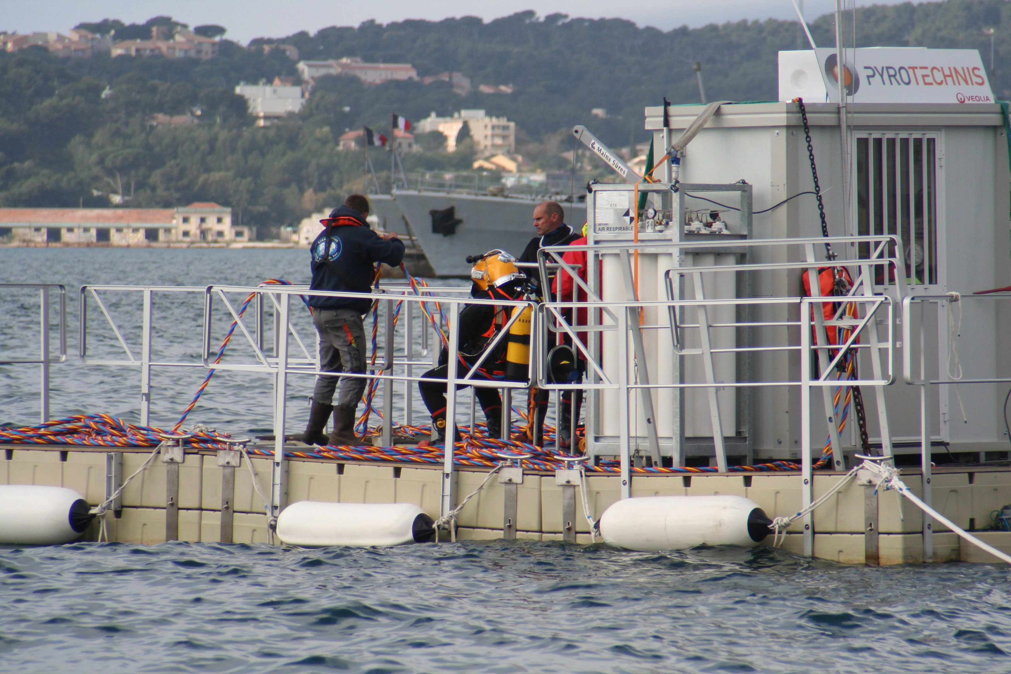 L'équipier du plongeur l'assiste pour s'habiller