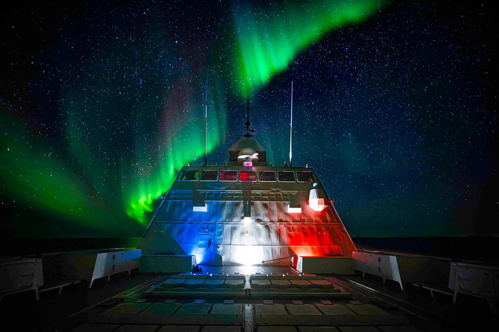 La frégate Normandie sous les aurores boréales au large de la Norvège