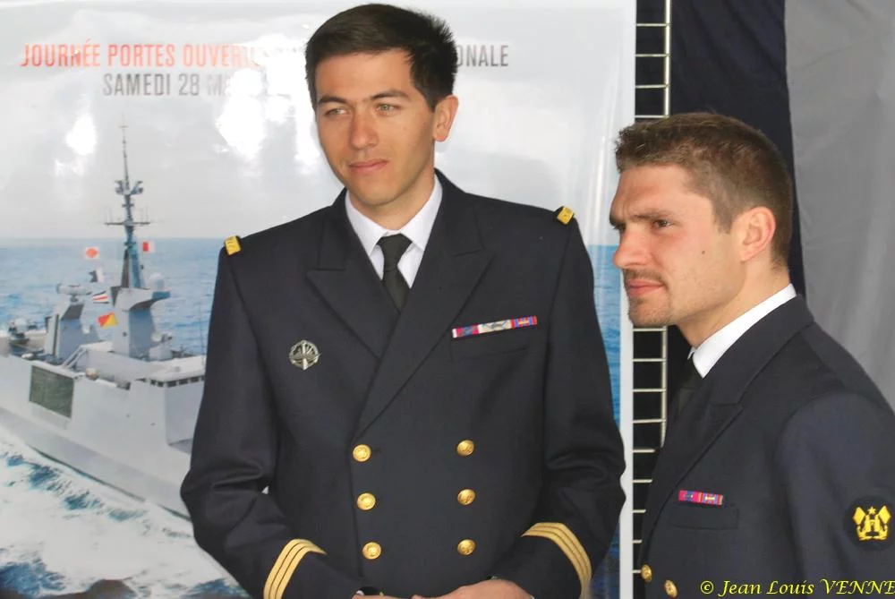 Les 2 marins devant les affiches de la campagne