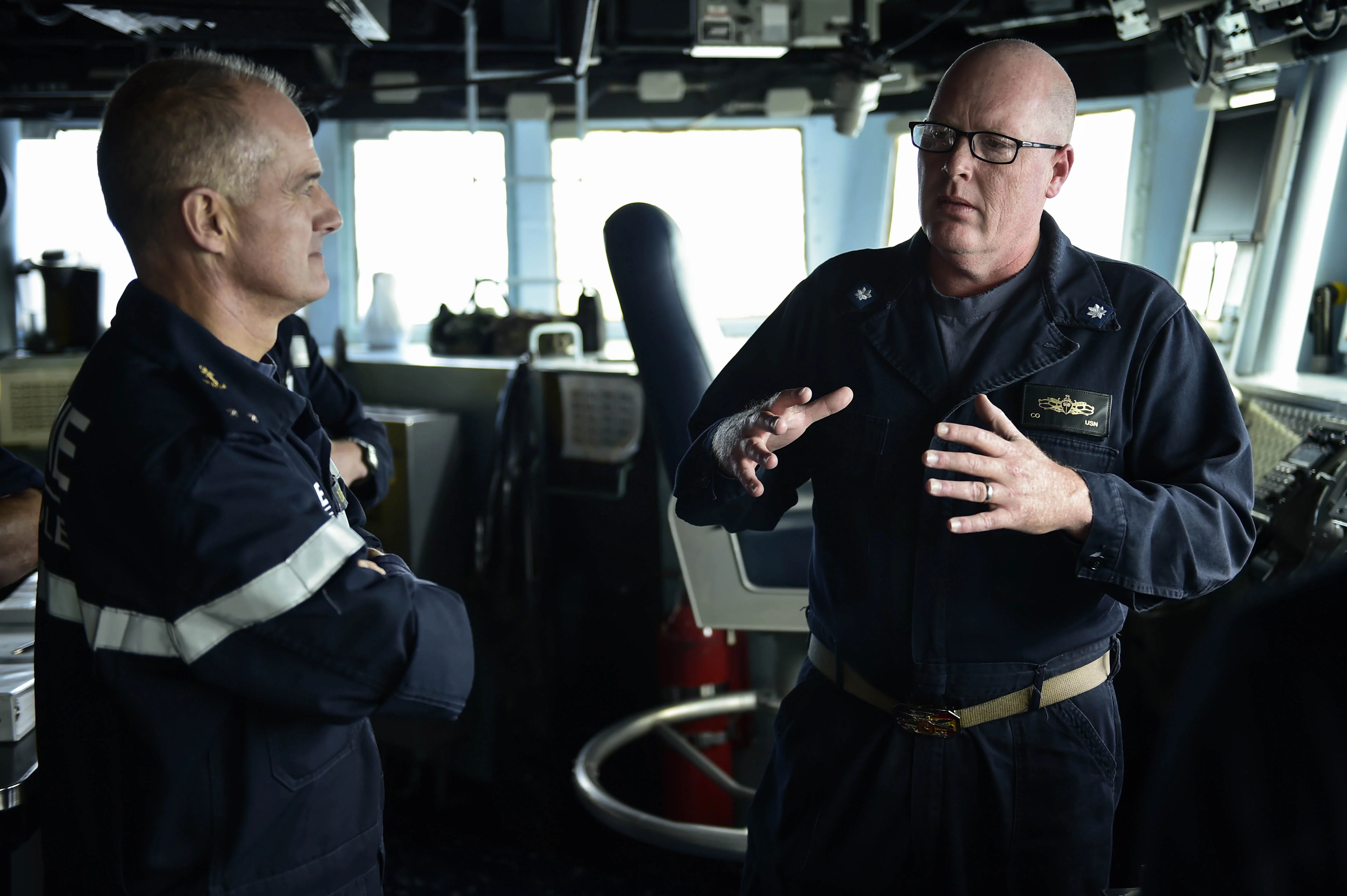 Le Cmdr. Russell Caldwell, commandant de l’USS Ross, fait visiter son destroyer au contre-amiral Lebas