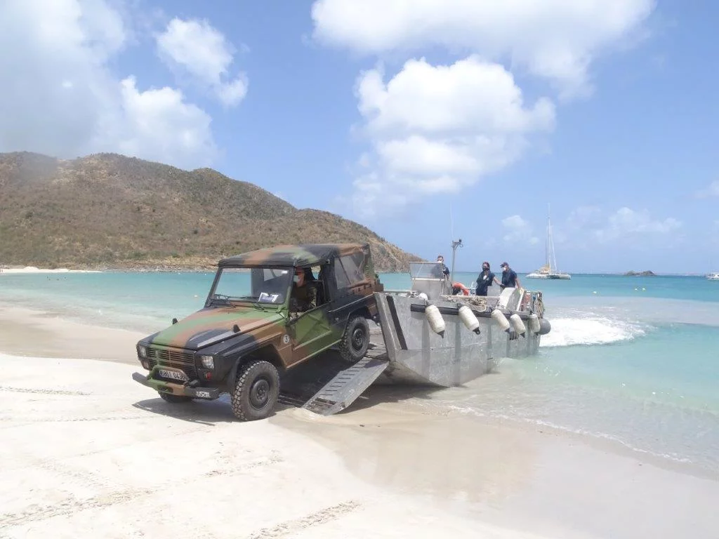 Une embarcation de servitude du Dumont d'Urville débarque un P4 sur une plage