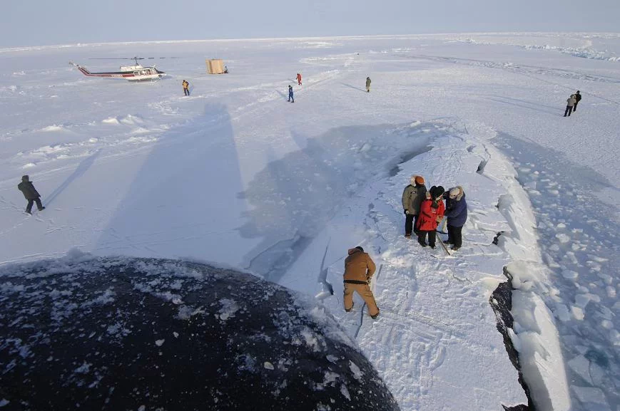 Des marins enlèvent la glace du panneau d'embarquement du SNA USS Alexandria