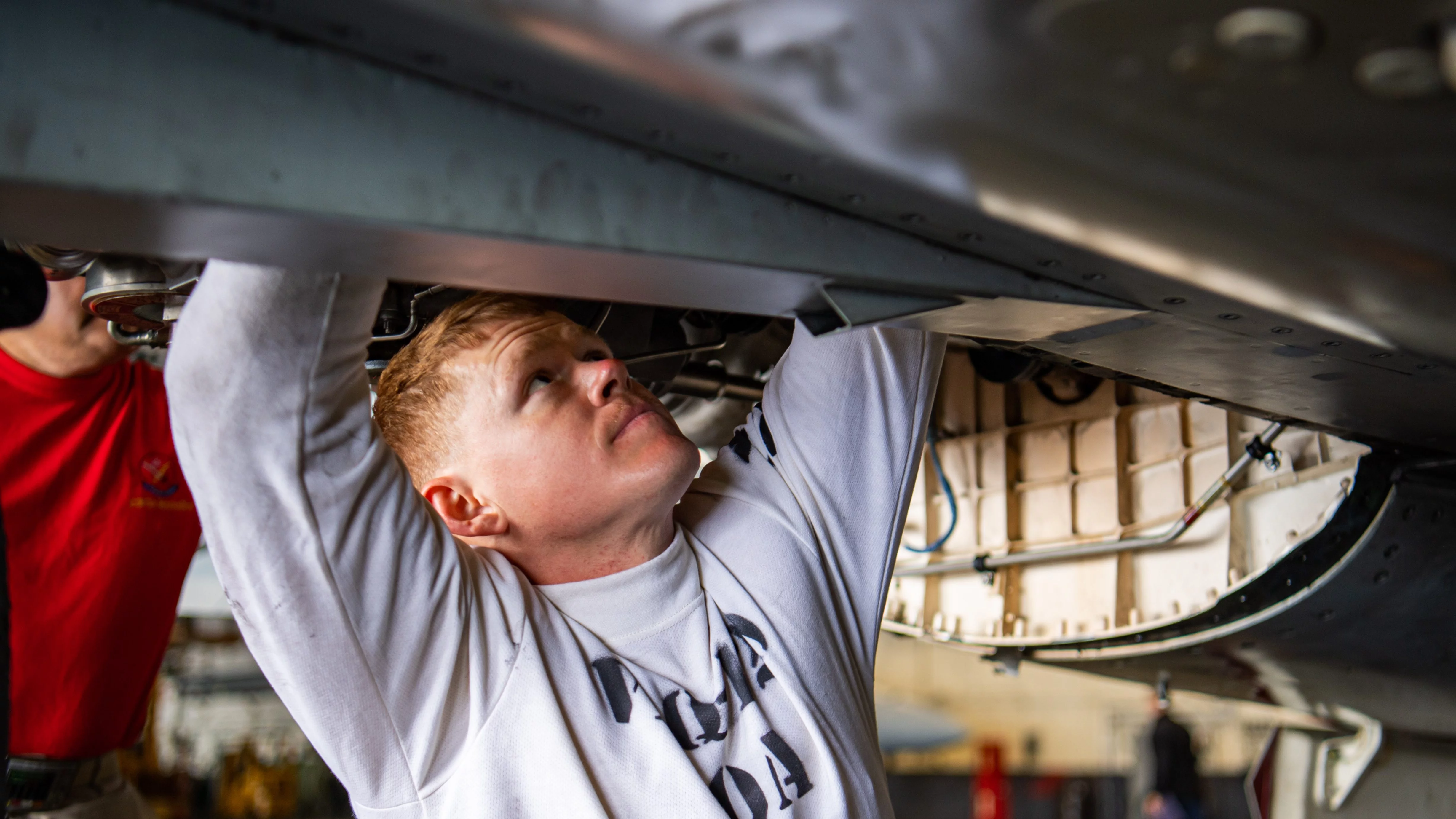 Un mécanicien du porte-avions USS Nimitz effectue des réparations sur un F/A-18